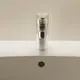 Armatur von Ideal Standard mit einem glänzenden Metallfinish, auf einem weißen Waschbecken angebracht, mit Bedienelementen und einem Wasserauslass auf der Seite.